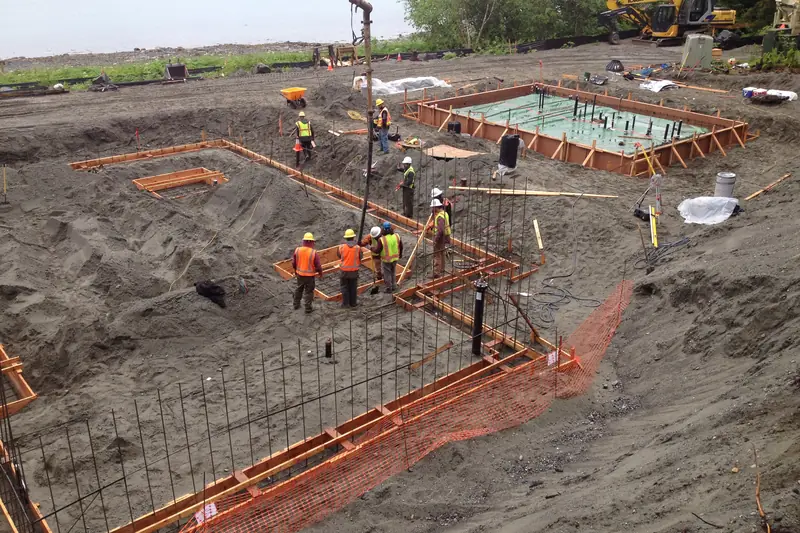 Concrete being pumped into foundation forms with steel rebar